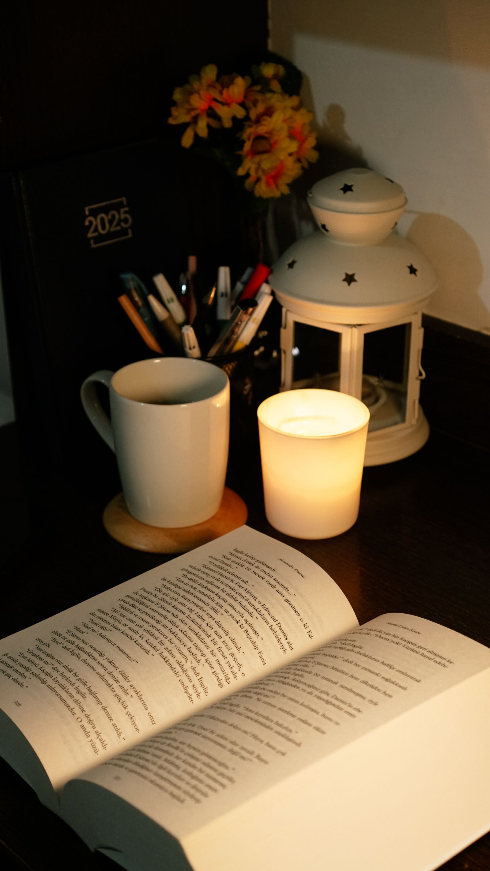 A cozy reading nook lit by candlelight, with an open book beside the flame