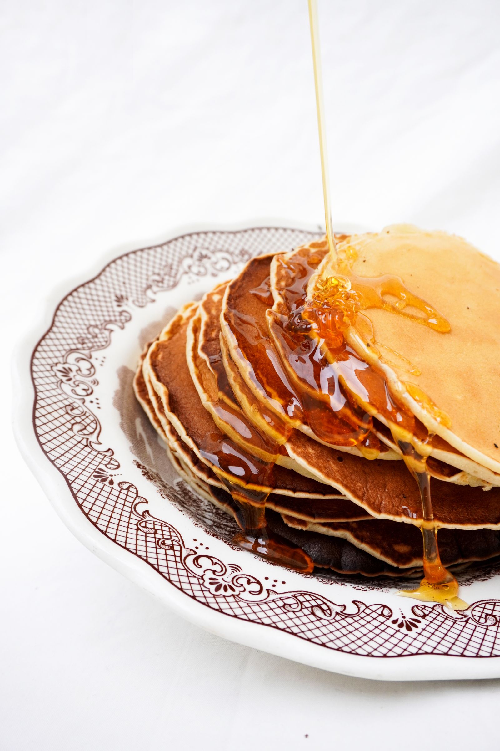 A stack of golden pancakes drizzled with maple syrup