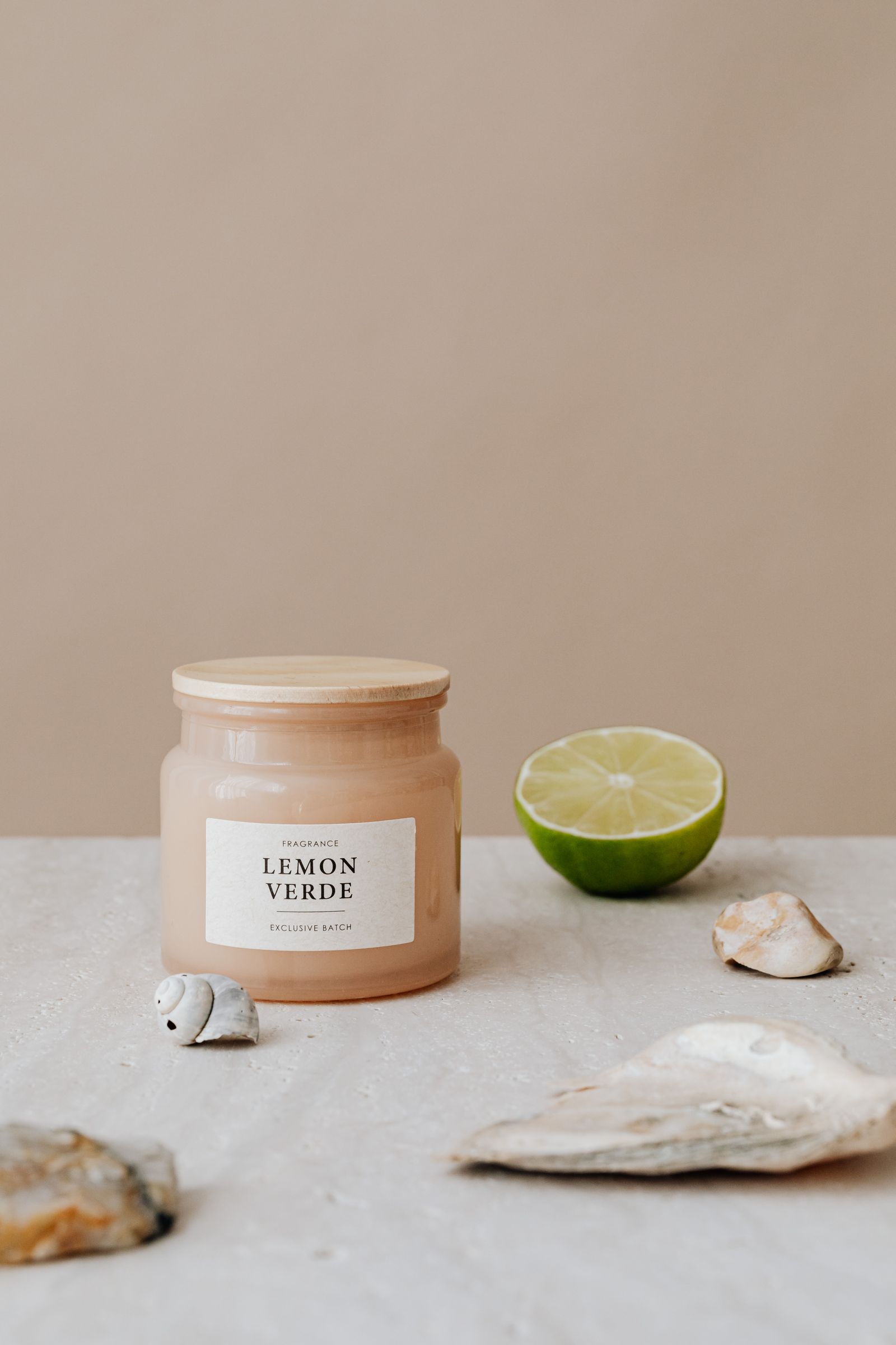 An aesthetic candle styled with lime and seashells